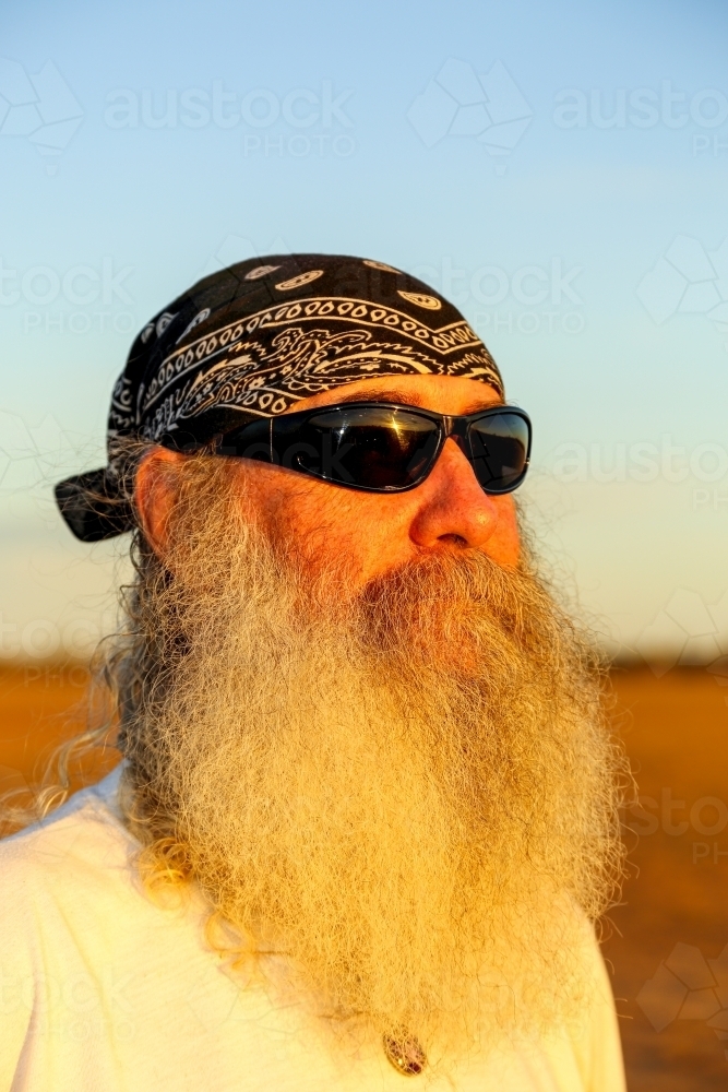 Man with full beard, sunglasses, and head scarf. - Australian Stock Image