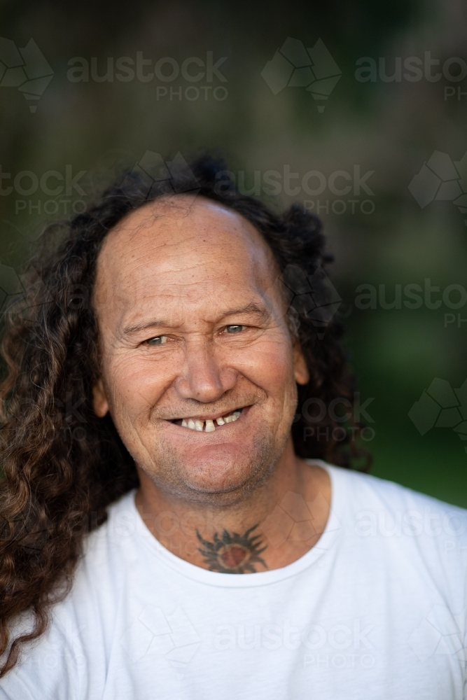 man with gap-toothed smile looking away - Australian Stock Image