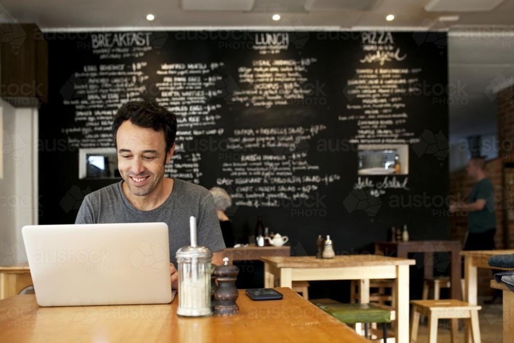 Man with laptop at a cafe - Australian Stock Image