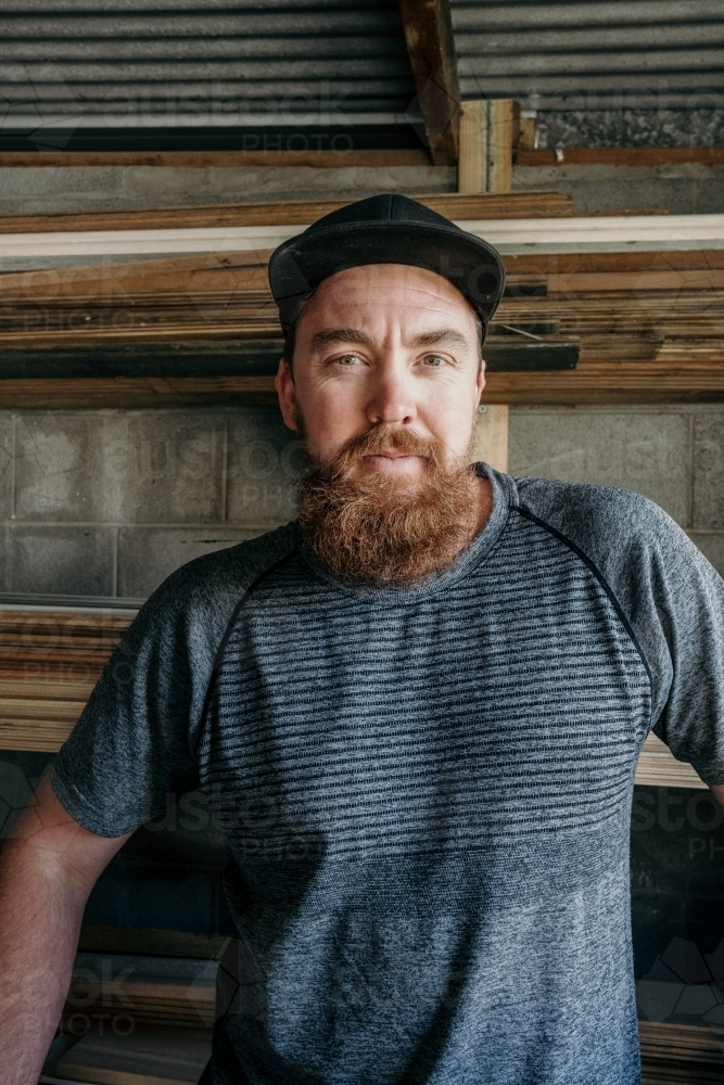 Man with long moustache standing in his timber workshop. - Australian Stock Image