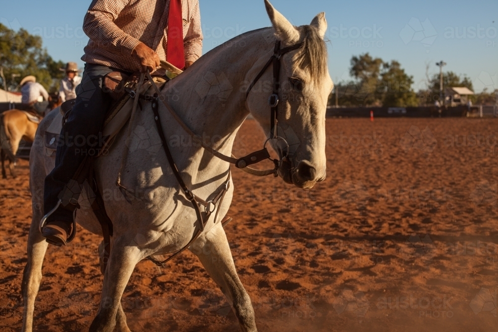 Mans riding horse in outback cattle yard - Australian Stock Image