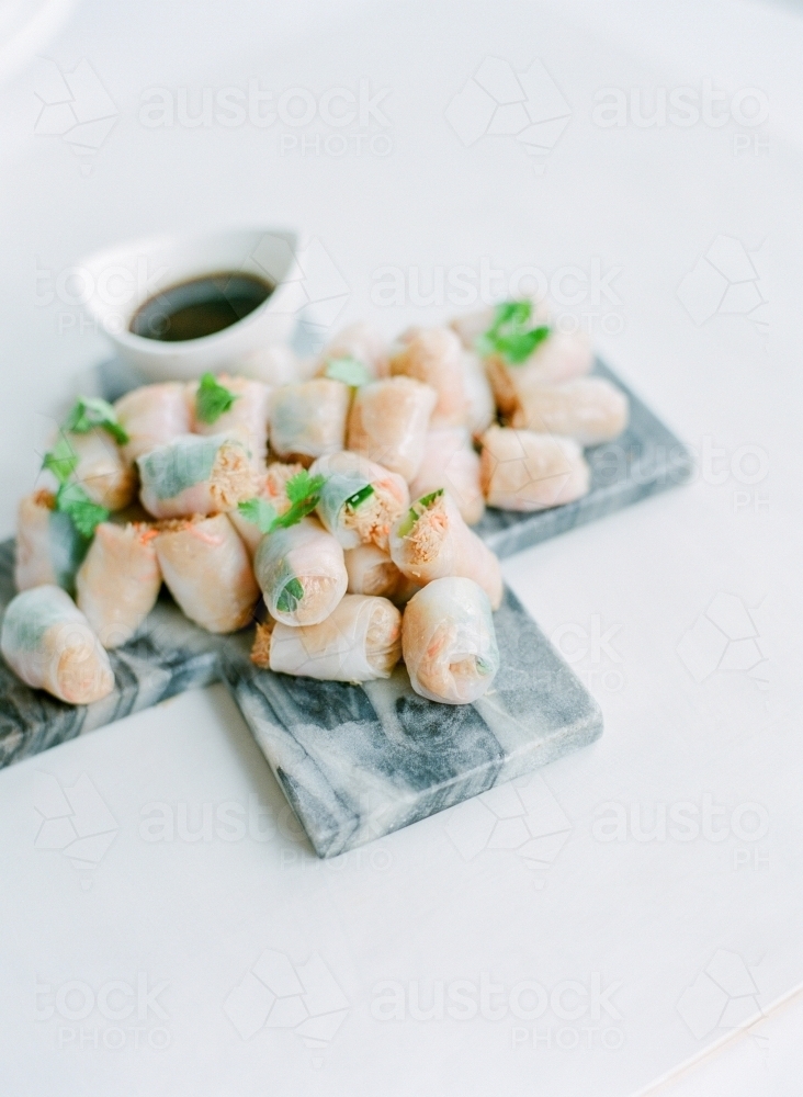 Marble platter of rice paper rolls with dipping sauce - Australian Stock Image