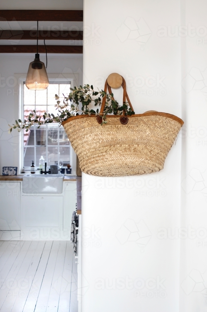 Market basket with eucalyptus leaves hanging on white wall with kitchen background : Austockphoto Market basket with eucalyptus leaves hanging on white wall with kitchen background - Australian Stock Image