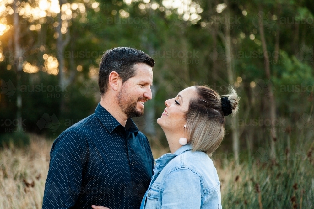 Married couple wife kisses husband in park - Australian Stock Image