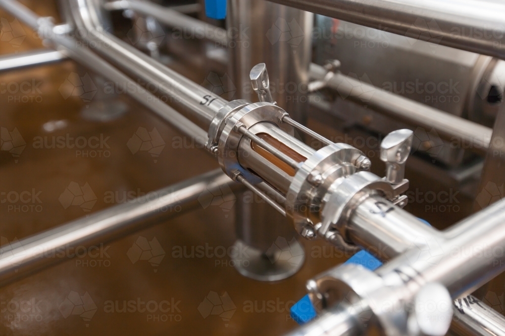 Mash running through stainless steel tube at a microbrewery - Australian Stock Image