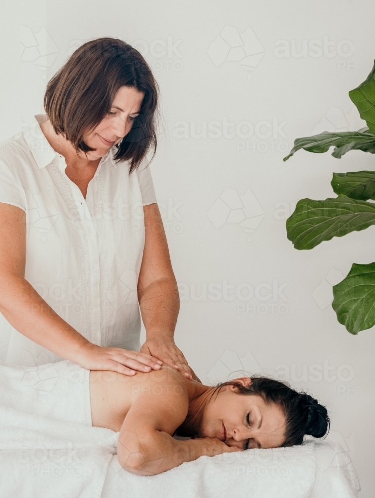 Masseuse gives a woman a back massage - Australian Stock Image