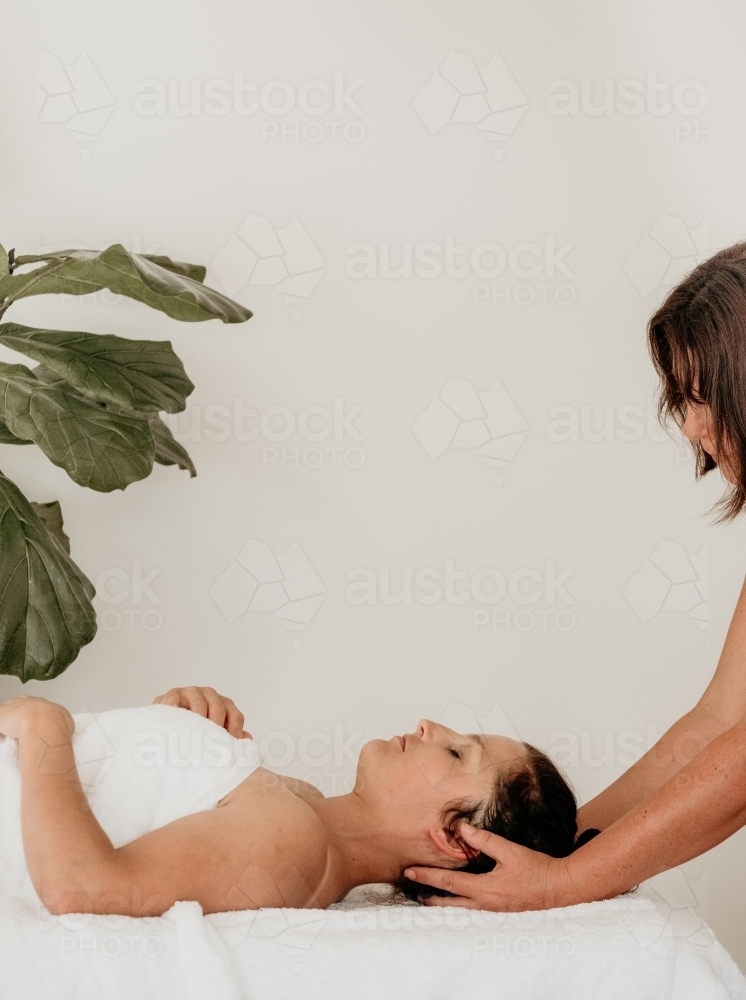 Masseuse working on a womans neck. - Australian Stock Image