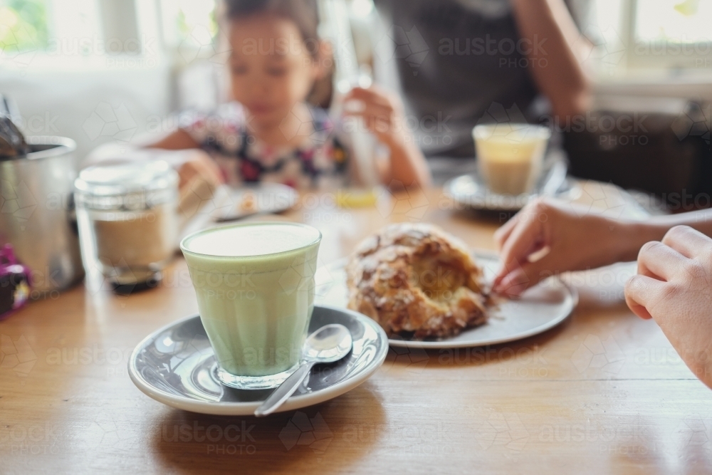 Matcha green tea latte with family background - Australian Stock Image