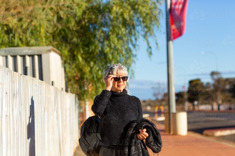 Mature aged woman walking down street in outback town - Australian Stock Image