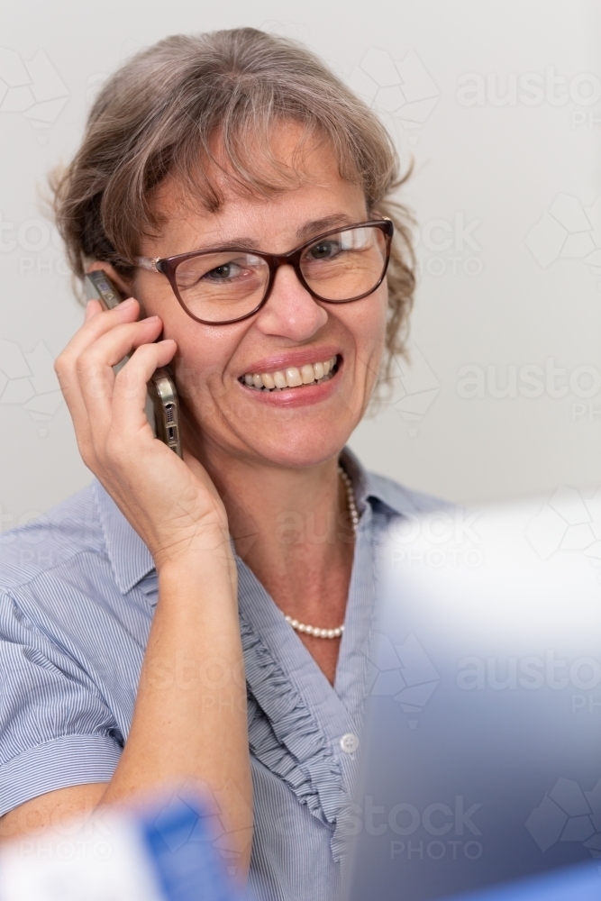 Mature business woman holding phone to ear - Australian Stock Image