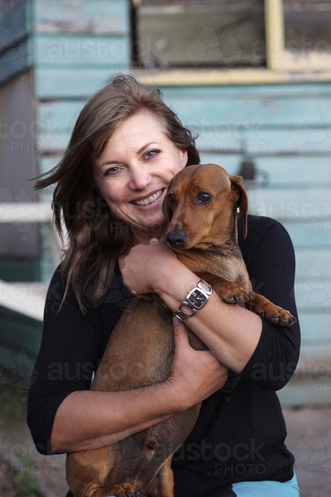 Mature woman holding dog - Australian Stock Image