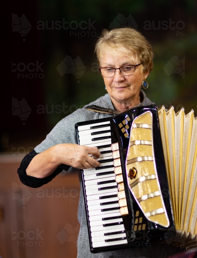 mature woman playing piano accordian - Australian Stock Image
