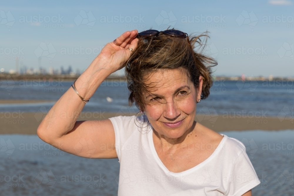 Mature woman pushing sunglasses back on her forehead - Australian Stock Image