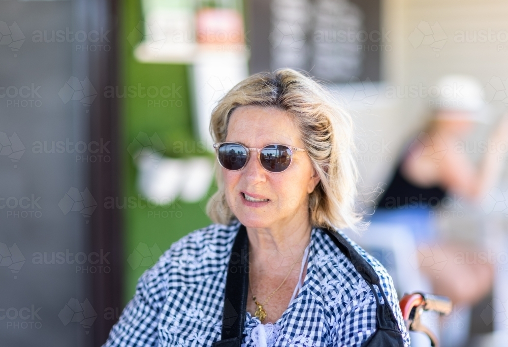 mature woman stroke survivor with crooked smile - Australian Stock Image