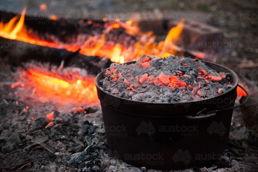 Image of Meal cooking in camping oven over campfires hot coals