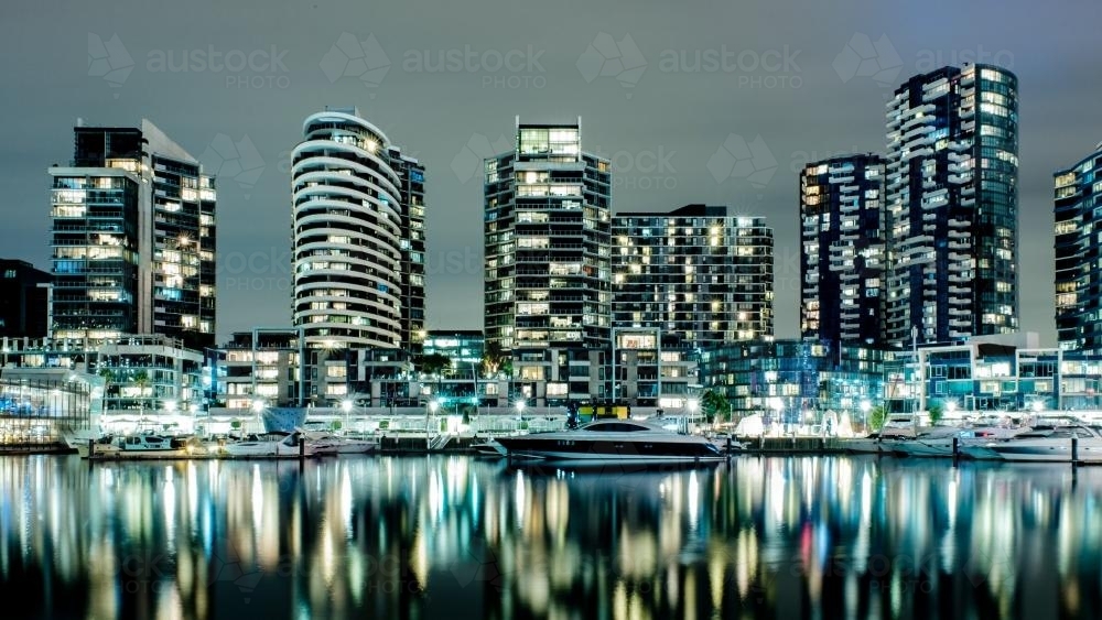 Melbourne dockland apartments reflected in water at night - Australian Stock Image