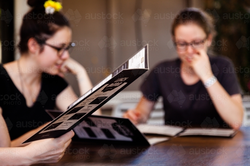 Menu at pub with blurred females in background - Australian Stock Image
