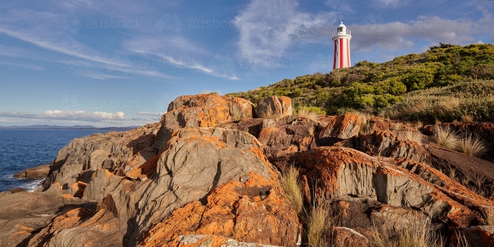 Mersey Bluff Lighthouse in Tasmania standing above lichen covered rocks. - Australian Stock Image