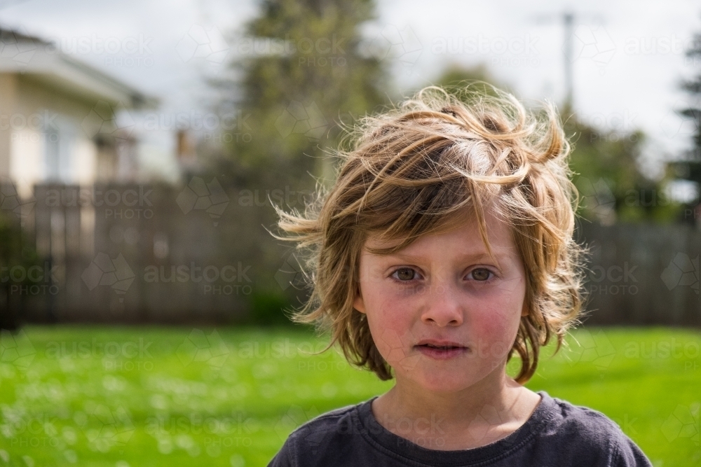 Messy haired little boy in a suburban setting - Australian Stock Image