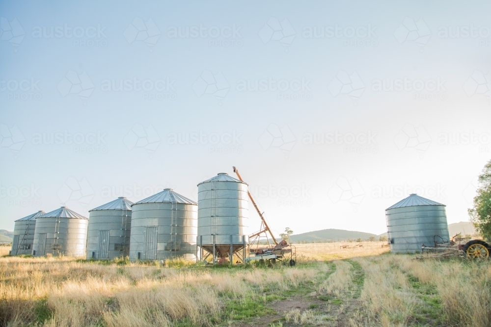 Metal grain silos on a farm in the morning - Australian Stock Image