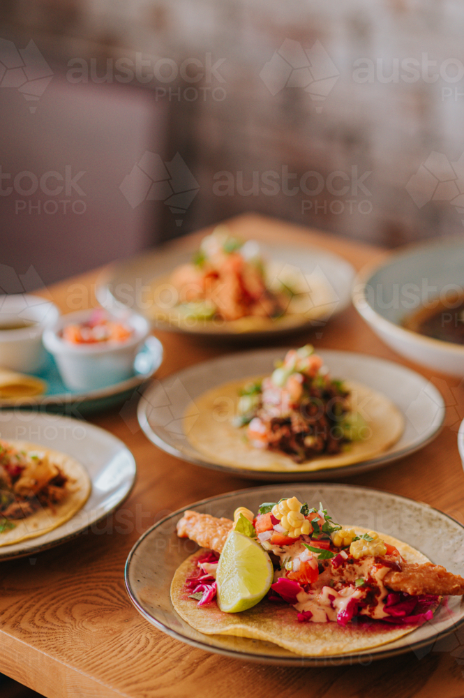 Mexican Tacos Served on Plates With Fresh Ingredients and Lime Wedge - Australian Stock Image