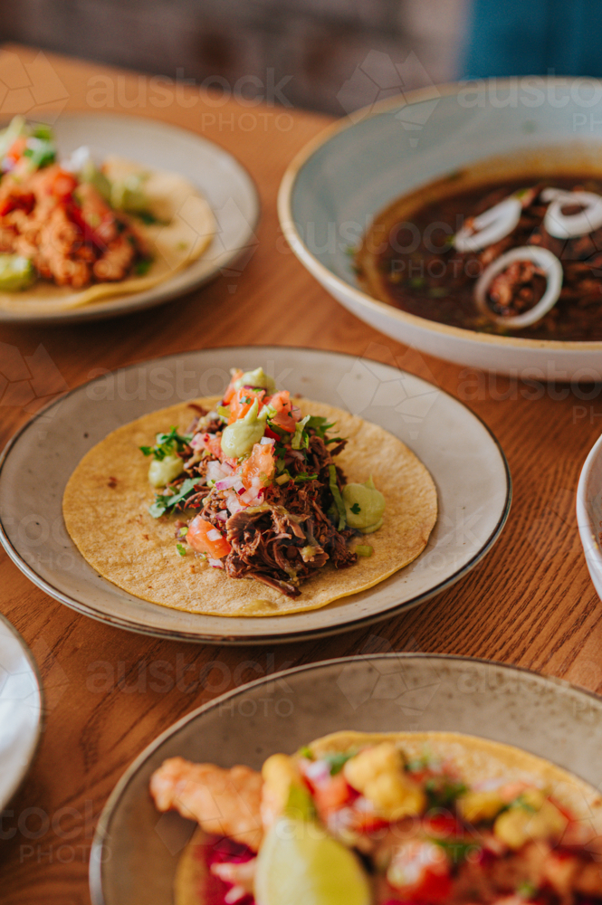 Mexican Tacos Served on Plates With Fresh Ingredients in a Cosy Dining Setting - Australian Stock Image