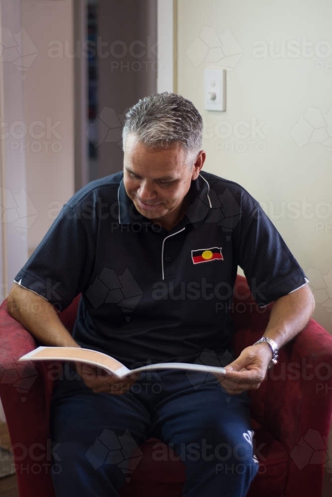 mid 40's aboriginal man reading - Australian Stock Image