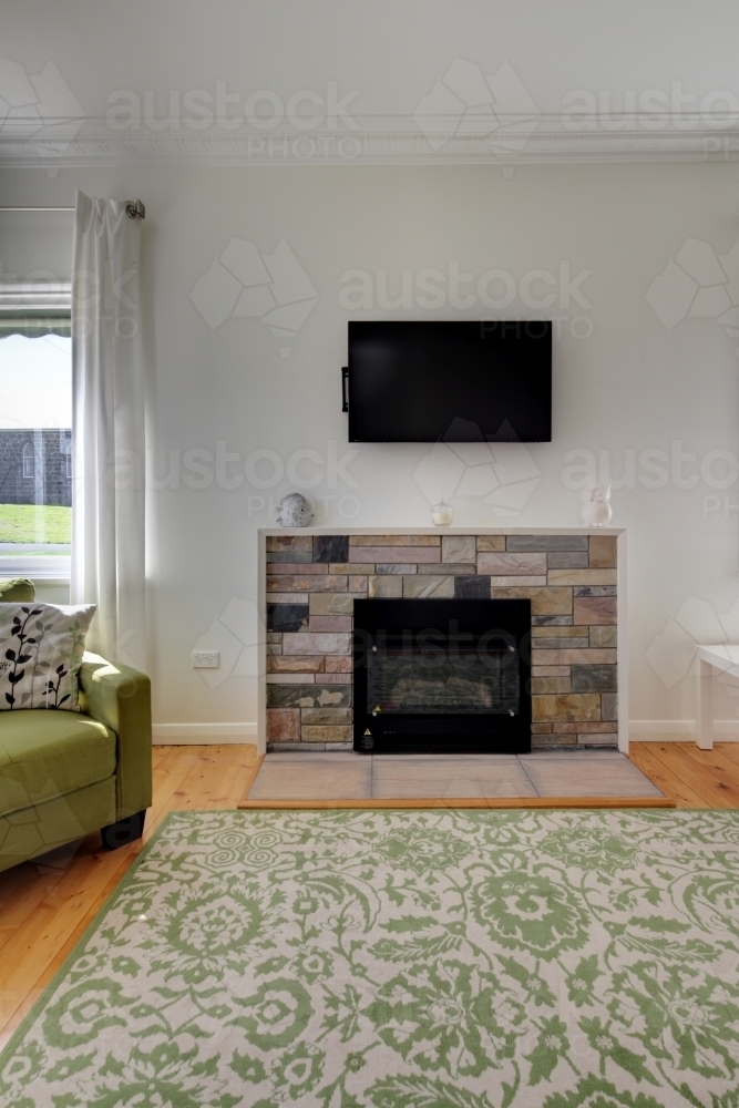 Mid-century style fireplace with TV on wall bracket - Australian Stock Image
