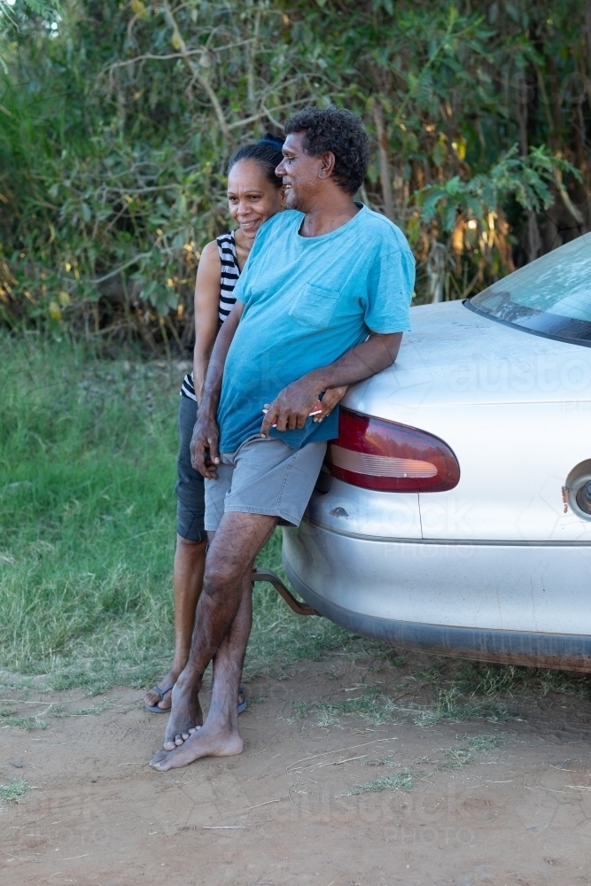 middle-aged couple leaning against the boot of their car - Australian Stock Image