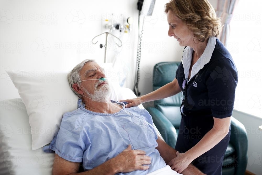 Middle aged male patient being treated by a nurse in a hospital ward - Australian Stock Image