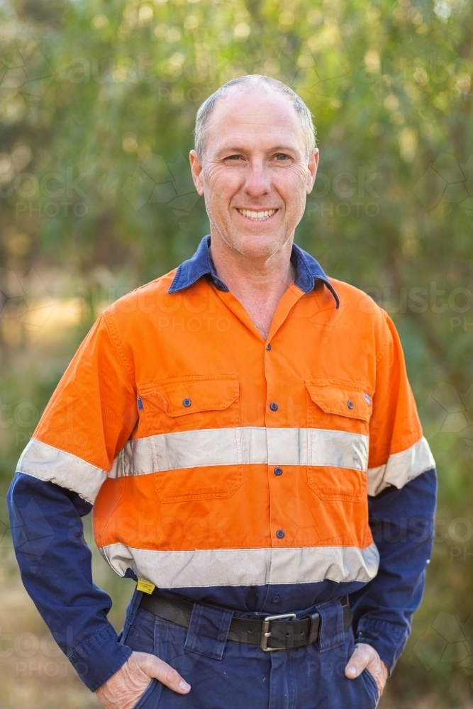 Middle aged man in high vis workwear smiling portrait outside - Australian Stock Image