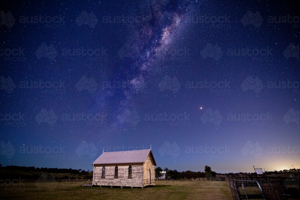 Milky way universe starry sky over rustic old timber chapel and  rural field in Australia - Australian Stock Image