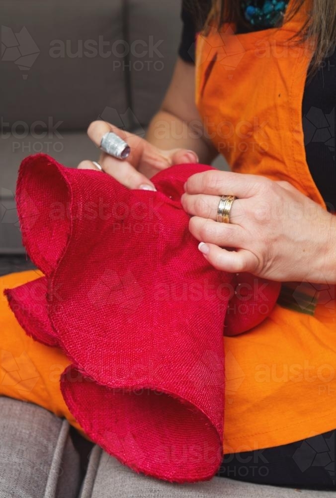 Milliner shaping a hat around a hat block - Australian Stock Image