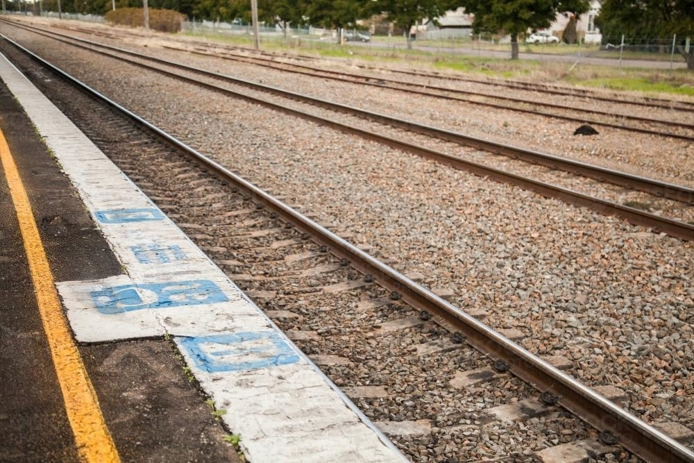 Mind the gap and yellow line painted signs at a train station - Australian Stock Image