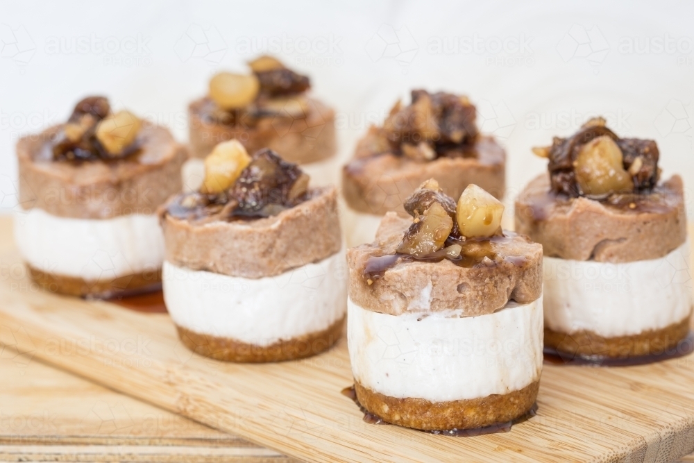 Mini raw Macadamia, choc cheesecakes served on a board - Australian Stock Image