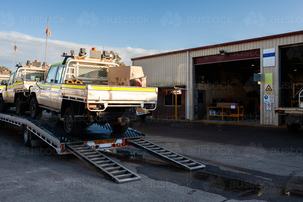 Mining fleet vehicles loaded on a flatbed trailer of truck being delivered to mechanics for repairs - Australian Stock Image