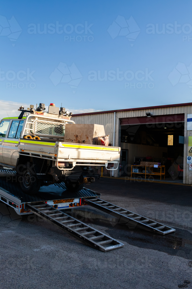 Mining fleet vehicles loaded on a flatbed trailer of truck being delivered to mechanics for repairs - Australian Stock Image