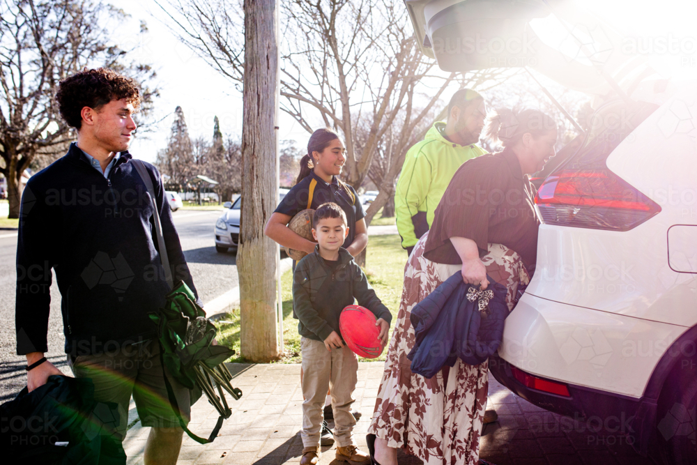 Mixed ethnicity family unpacking car boot - Australian Stock Image