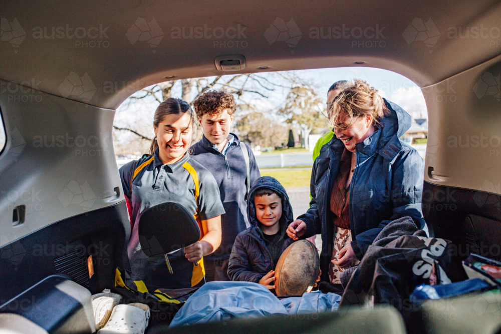 Mixed ethnicity family unpacking car boot - Australian Stock Image