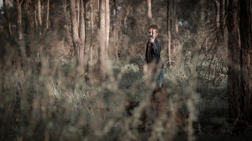 Mixed race boy walks with walkie talkie in Sydney bushland - Australian Stock Image