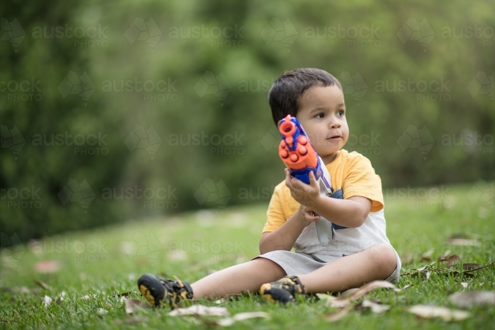 Mixed race boys playing outside with Nerf dart guns - Australian Stock Image