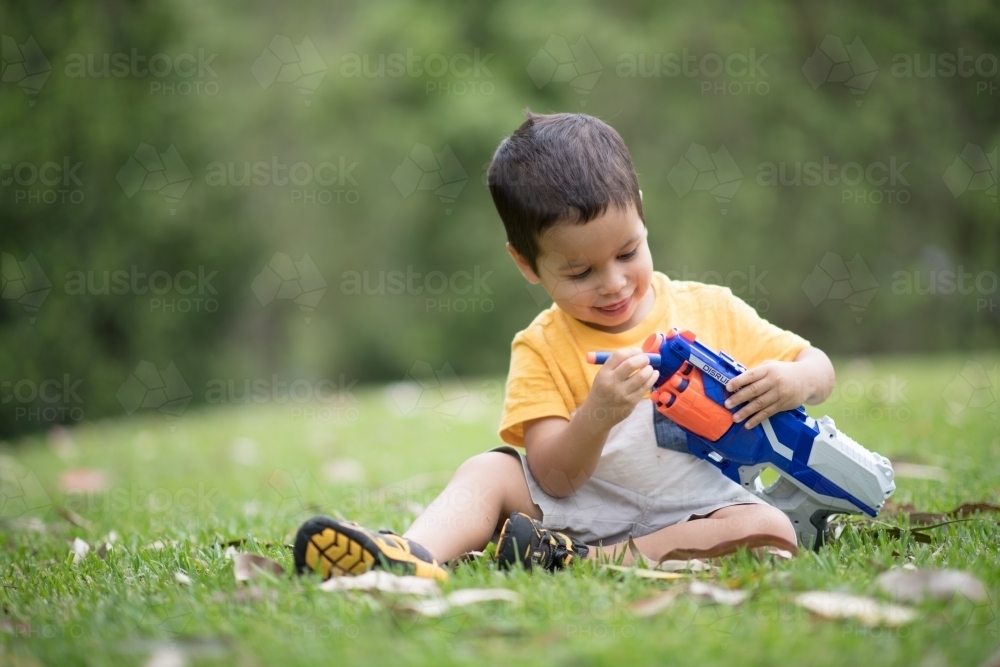 Mixed race boys playing outside with Nerf dart guns - Australian Stock Image