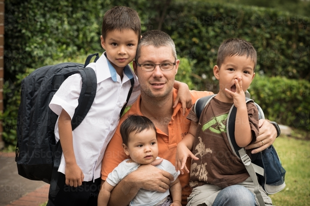Mixed race boys say good-bye to their dad on their first day of school - Australian Stock Image