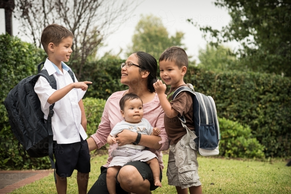 Mixed race boys say good-bye to their mum on their first day of school - Australian Stock Image