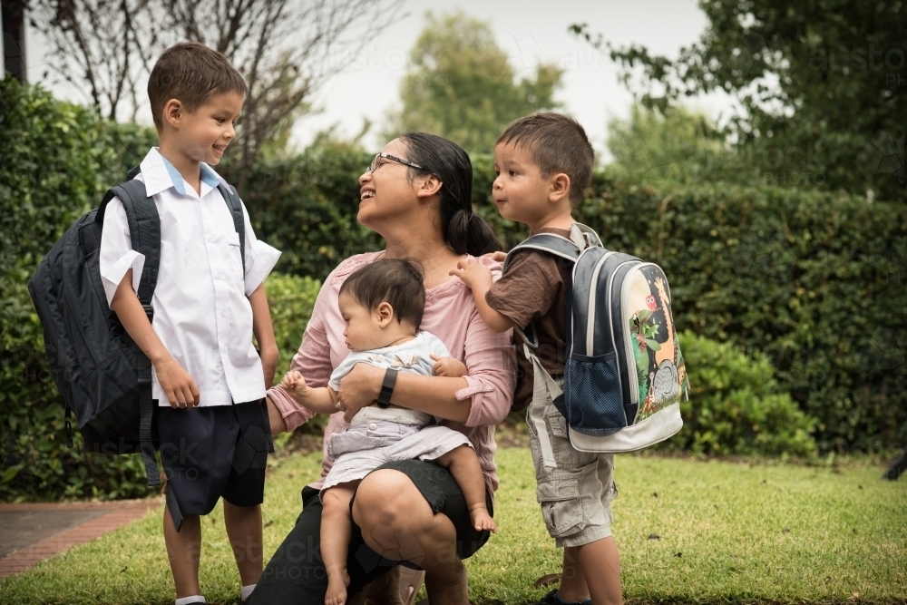 Mixed race boys say good-bye to their mum on their first day of school - Australian Stock Image