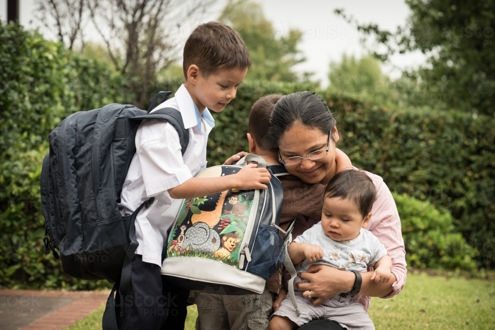 Mixed race boys say good-bye to their mum on their first day of school - Australian Stock Image
