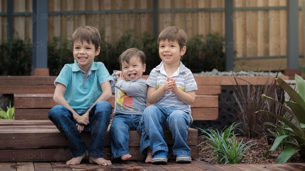 Mixed race brothers play together in their suburban backyard - Australian Stock Image