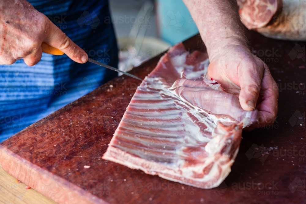 mobile butcher cutting up lamb meat - Australian Stock Image