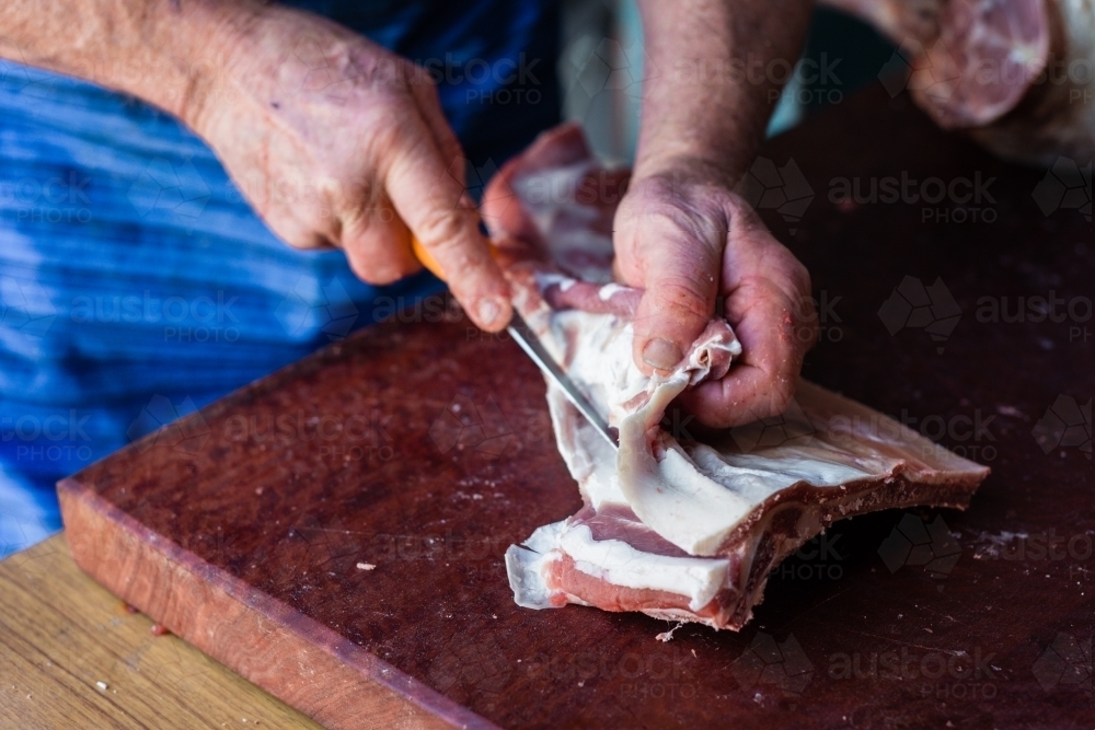 mobile butcher cutting up lamb meat - Australian Stock Image