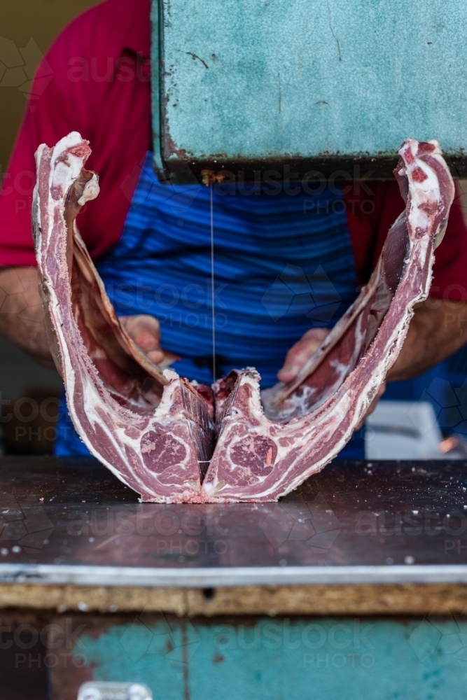 mobile butcher using electric saw to cut through bones - Australian Stock Image